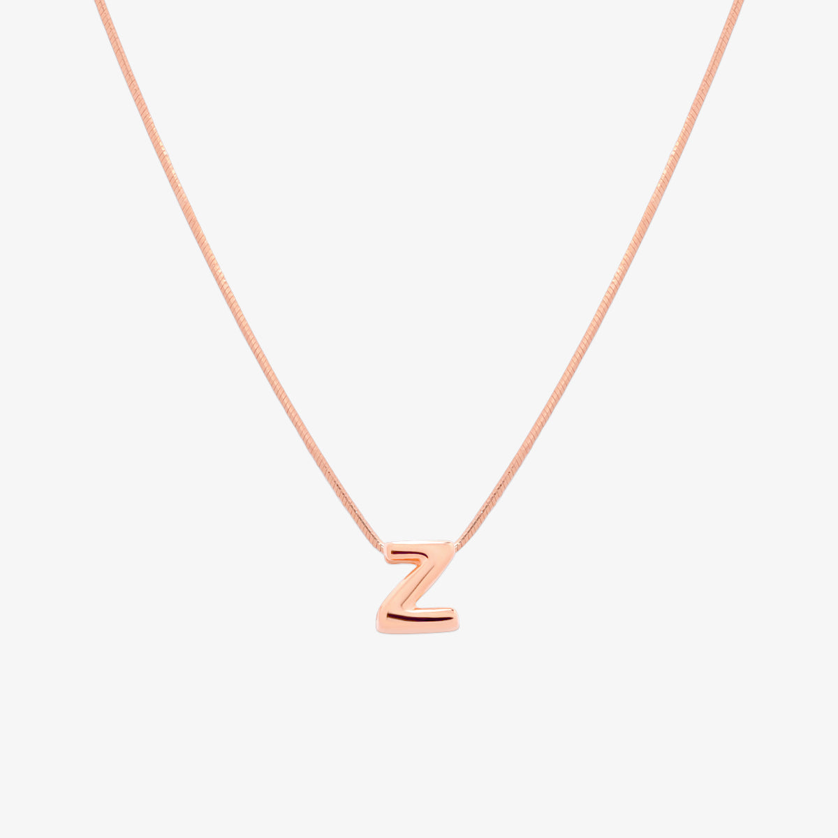 Bubble initial pendant necklace featuring a rounded, playful letter charm on a sleek snake chain, with a smooth and glossy finish.